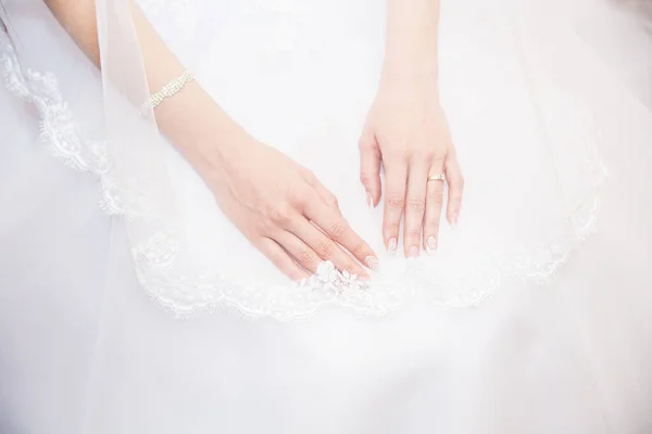 Manos novia con una manicura, en el dedo del anillo de bodas de la novia . — Foto de Stock