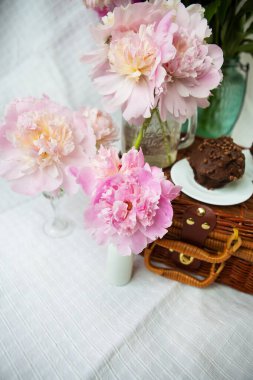 Çok güzel bir buket pembe şakayık tahta bir bavulun üzerinde duruyor. Güzel kompozisyon.