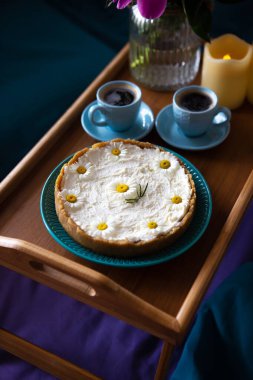 Üst görünüm - yatakta kahvaltı lezzetli bir cheesecake ve kahve iki fincan ahşap bir tepsi üzerinde.