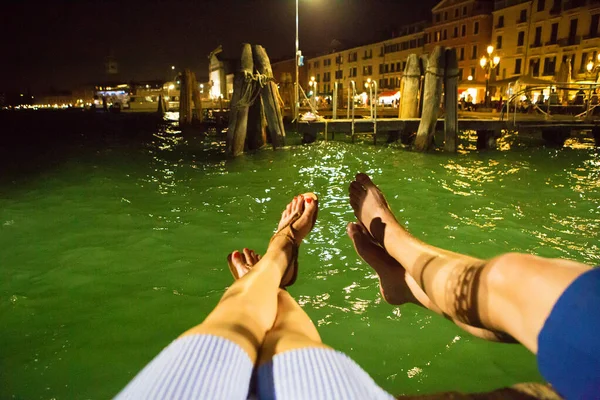 Вечором на кінці дерев "яного стовпа у Венеції сидить любляча пара. — стокове фото