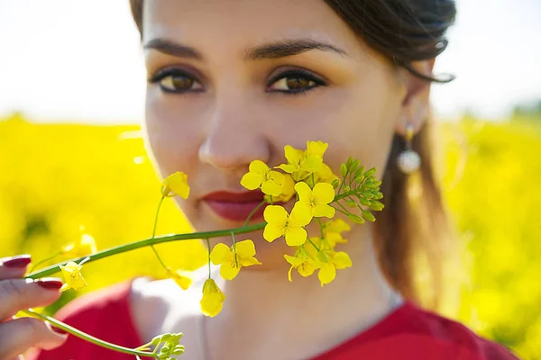 Girl holding yellow flower near face, close-up — 图库照片