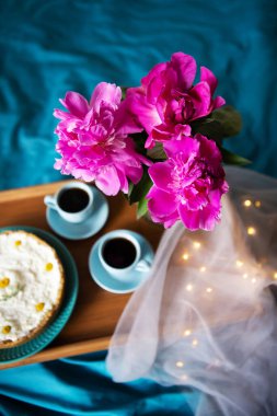 Güzel sabah Vanilyalı cheesecake, kahve, mavi bardak, cam vazo pembe şakayık