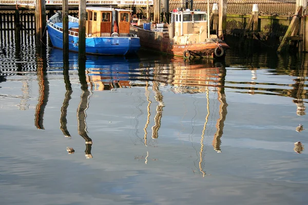 Reflections of fishingboats in harbour — Stock Photo, Image