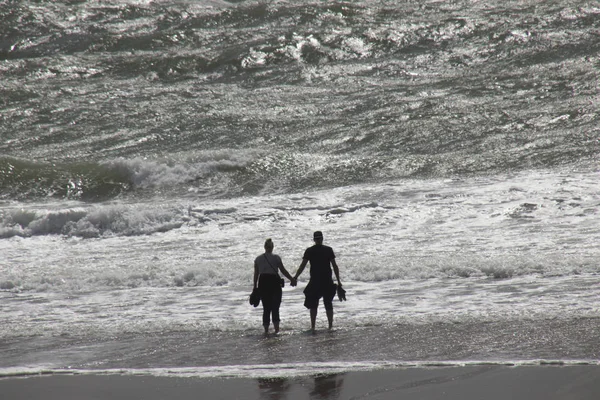 Menschen spielen im Sturm am Strand — Stockfoto