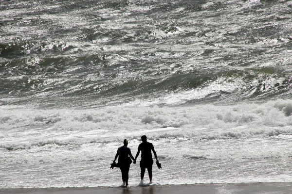 Menschen spielen im Sturm am Strand — Stockfoto