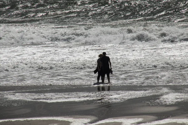 Люди играют на пляже во время шторма — стоковое фото