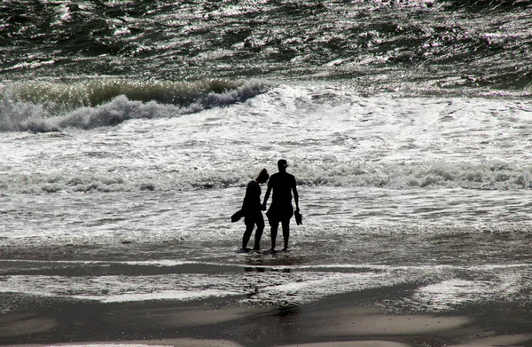 Menschen spielen im Sturm am Strand — Stockfoto