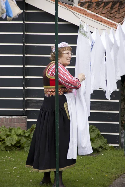 Habitante mayor de Marken en traje Folk hace la colada — Foto de Stock