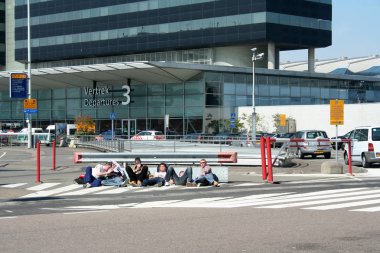 Genç Schiphol önünde bekleyen yolcular