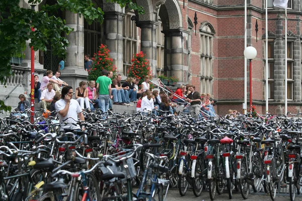 De nombreux vélos sont garés devant le bâtiment historique de l'Université dans le Centre — Photo