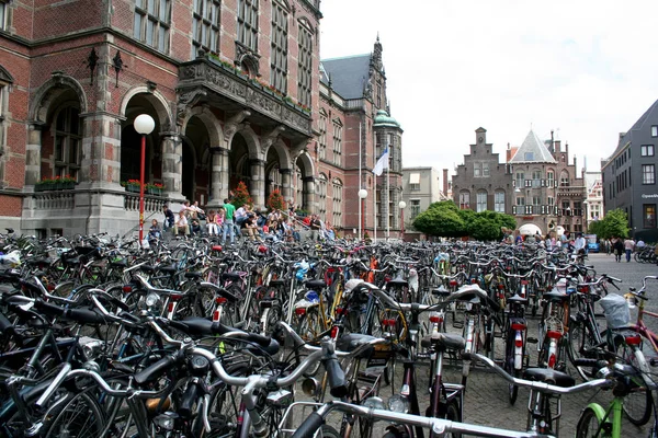 Molte biciclette sono parcheggiate di fronte allo storico edificio universitario del centro — Foto Stock