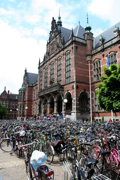 Molte biciclette sono parcheggiate di fronte allo storico edificio universitario del centro — Foto Stock