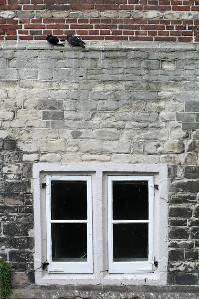Окно в старой стене в центре города — стоковое фото