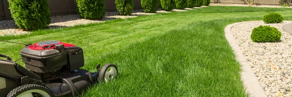 Cortador de grama na grama verde — Fotografia de Stock