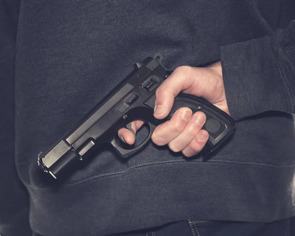 Armed Persona Sosteniendo Pistola Con Pantalones Vaqueros Azul Oscuro Sudadera — Foto de Stock