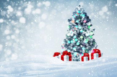 Kar arka plan açık havada düşen hediyeler ile süslenen Noel ağacı 