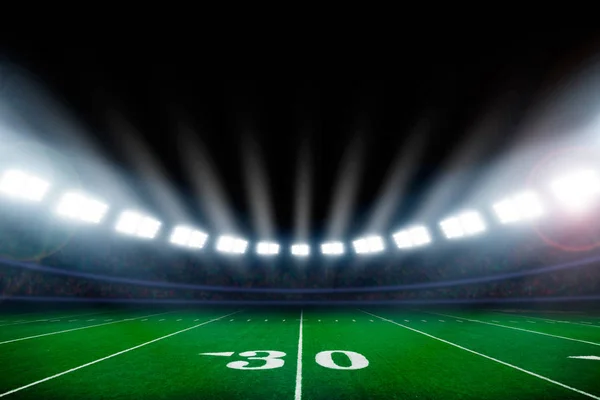 スタジアムのライトに照らされたアメリカン フットボール フィールド — ストック写真