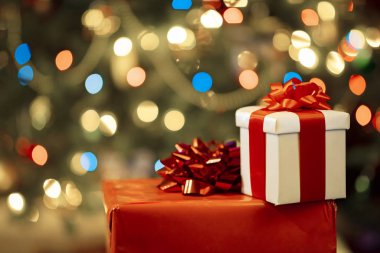 Kurdeleli hediye kutuları ve tatil ışıkları arka planında yay