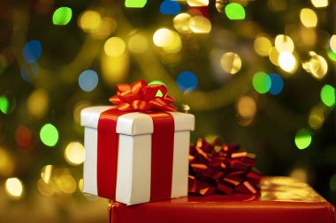 Kurdeleli hediye kutuları ve tatil ışıkları arka planında yay