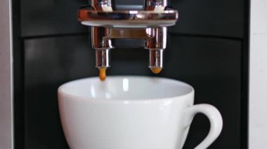Espresso makinesinden beyaz kahve bardağına taze kahve yapmak.