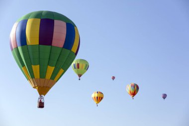 Güneşli bir günde mavi gökyüzünde sıcak hava balonları