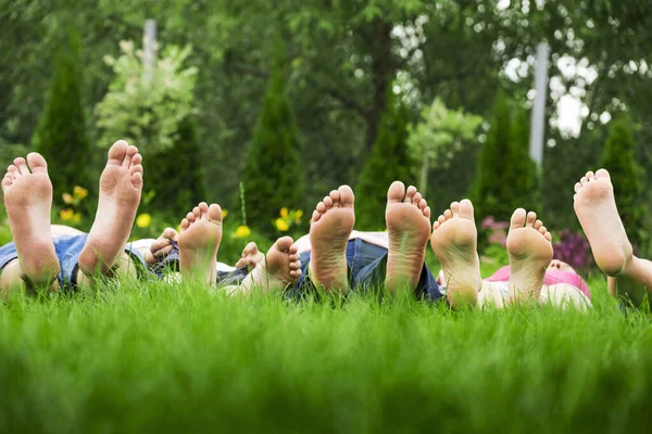 Aile Yeşil Çimlerde Dinleniyor Yalınayak Uzanıyor Gökyüzüne Bakıyor — Stok fotoğraf
