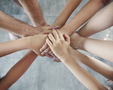 El ele tutuşan bir grup insan, takım çalışmasında başarı.