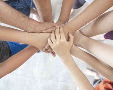 El ele tutuşan bir grup insan, takım çalışmasında başarı.