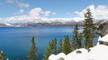 Baharda Tahoe Gölü 'nün turkuaz suları Sierra Nevada dağlarının karlı zirveleriyle