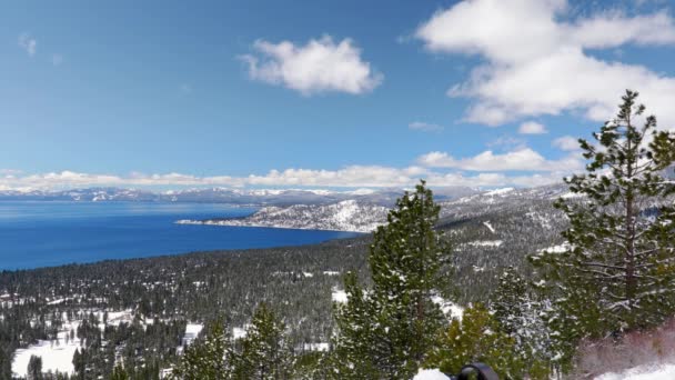 地面に雪とタホ湖のパノラマとシエラネバダ山脈のピークを表示します — ストック動画