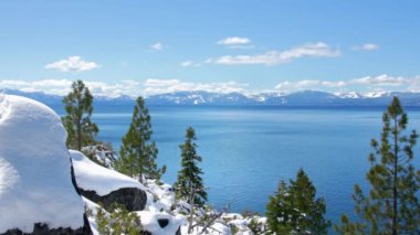 Baharda Tahoe Gölü 'nün turkuaz suları Sierra Nevada dağlarının karlı zirveleriyle