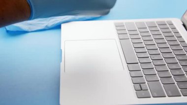 Diz üstü bilgisayar, güvenli iş yeri, 4K kullanmadan önce koruyucu lateks eldiven takan kişi.