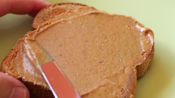 Espalhando Manteiga Amendoim Cremosa Torrada Trigo Integral Escolha Café Manhã — Vídeo de Stock