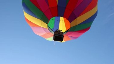 Mavi gökyüzünde uçan sıcak hava balonu, çok renkli çizgiler, 4k 