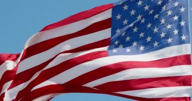 Mavi gökyüzünde rüzgarda dalgalanan Amerikan bayrağı, yakın planda Amerikan bayrağı, açık havada kırmızı mavi bayrak. Amerika Birleşik Devletleri ulusal bayrağı. ABD 'li yıldızlar ve çizgiler, 4k DCI