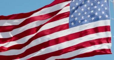 Mavi gökyüzünde rüzgarda dalgalanan Amerikan bayrağı, yakın planda Amerikan bayrağı, açık havada kırmızı mavi bayrak. Amerika Birleşik Devletleri ulusal bayrağı. ABD 'li yıldızlar ve çizgiler, 4k DCI