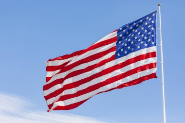 Mavi gökyüzünde rüzgarda dalgalanan Amerikan bayrağı, yakın planda Amerikan bayrağı, açık havada kırmızı mavi bayrak. Amerika Birleşik Devletleri ulusal bayrağı. ABD yıldızları ve çizgileri