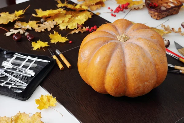 Still life with pumpkin and carving tools — Stock Photo, Image