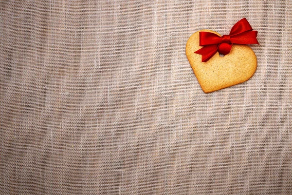 Heart shaped gingerbread cookie with red ribbon — Stock Photo, Image