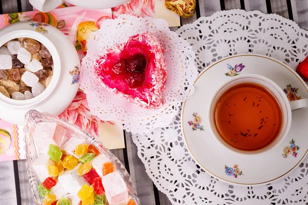 Porcelain cup of tea with lemon and sweets — Stock Photo, Image