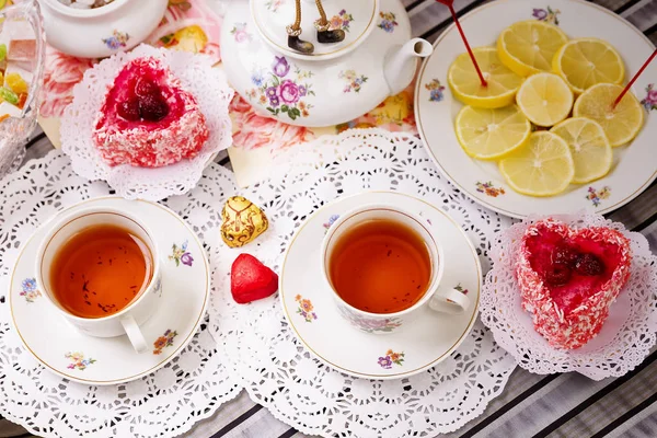Porcelánový šálek čaje s citronem a sladkosti — Stock fotografie