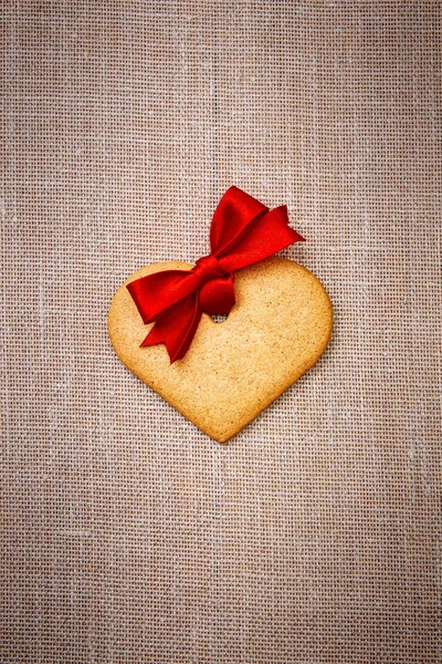 Heart shaped gingerbread cookie with red ribbon — Stock Photo, Image