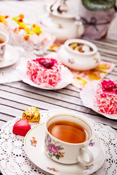 Xícara de chá de porcelana com limão e doces — Fotografia de Stock