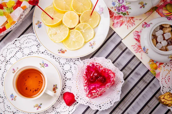 Xícara de chá de porcelana com limão e doces — Fotografia de Stock