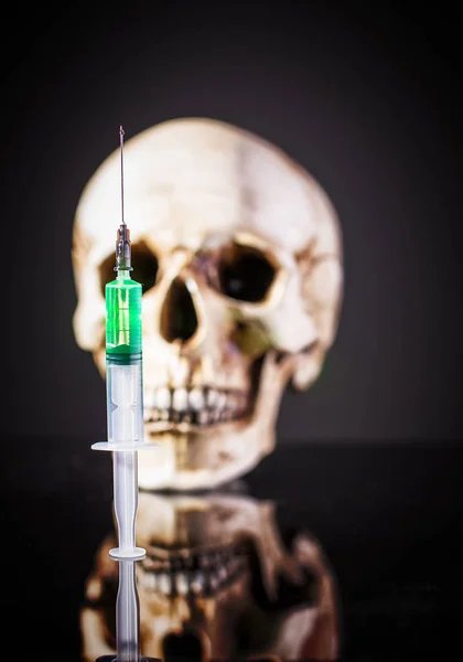 Syringe over human skull — Stock Photo, Image