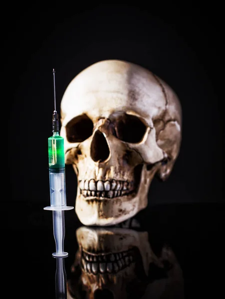 Syringe over human skull — Stock Photo, Image