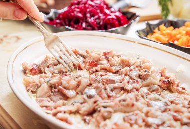 geleneksel Rus salatası ringa kürk altında hazırlanıyor