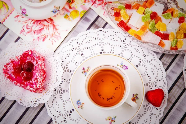 Porcelain cup of tea with lemon and sweets — Stock Photo, Image