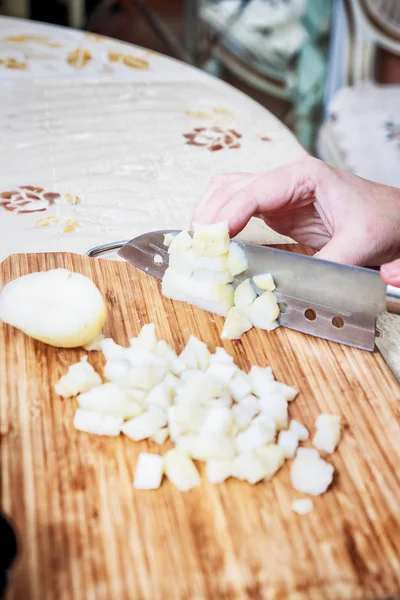 Жінки рука з ножем, що ріже киплячу картоплю — стокове фото