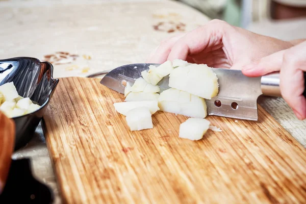 Womans hand with a knife cutting the boiling potatoes — Stock Photo, Image